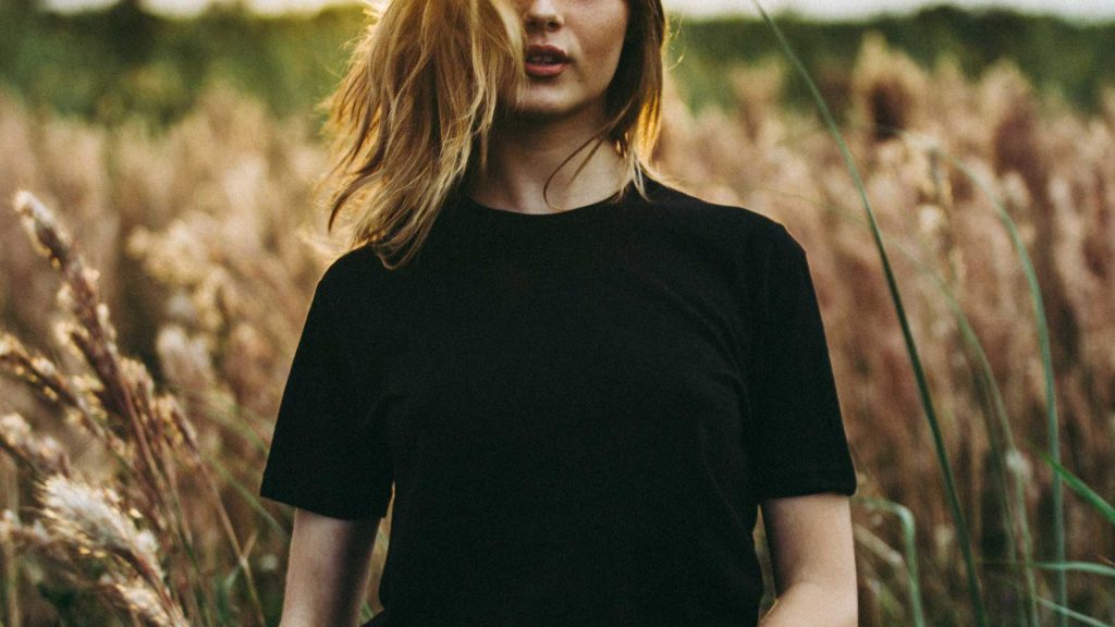 Woman wearing black t-shirt in grassy field